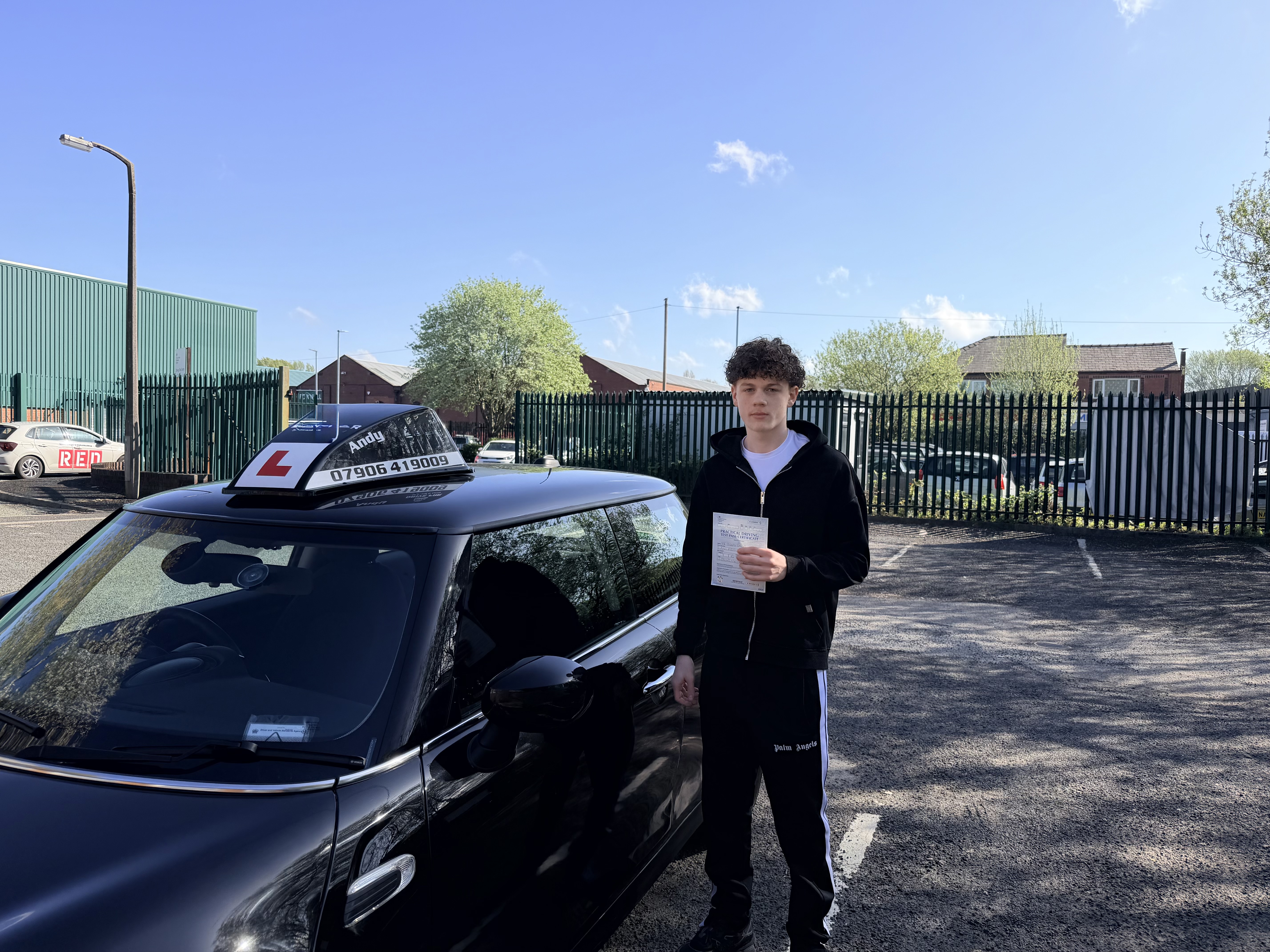 Successful learner beside the driving school car